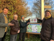 Cllr Wilkins (L) and Sarah Dyke MP (R), MP for Glastonbury and Somerton, with Pitney Biodiversity Working Group members by village sign.