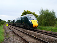 GWR Intercity Train through Rural Countryside running on tracks, green fields and trees beside the line in Somerset.