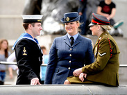Three UK service members chatting beside a fountain, with a large lion statue in the background, ©UK MOD Crown Copyright.