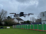 A drone hovering over grass.