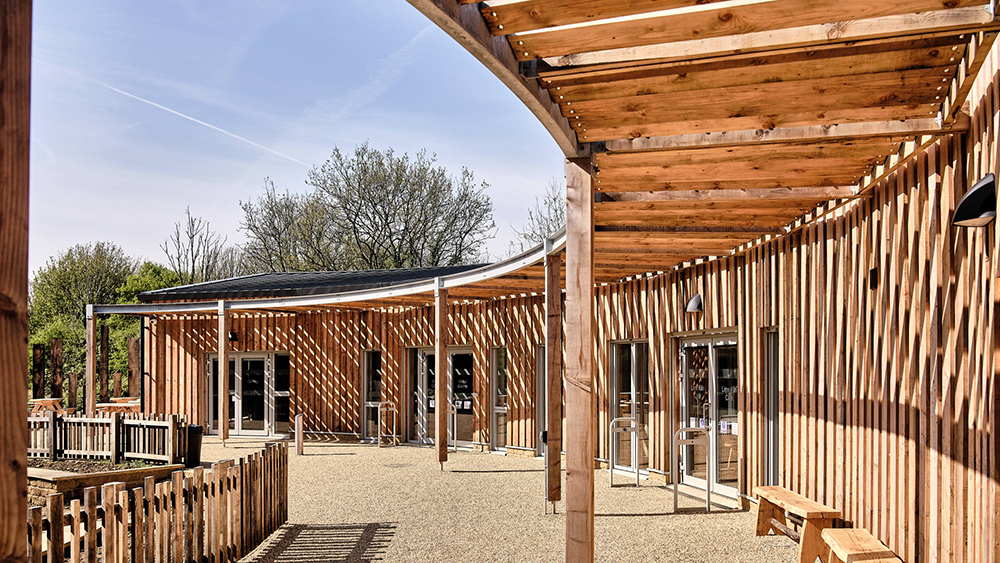Ham Hill Visitor Centre exterior, showing timber-clad buildings, covered walkway and courtyard area.