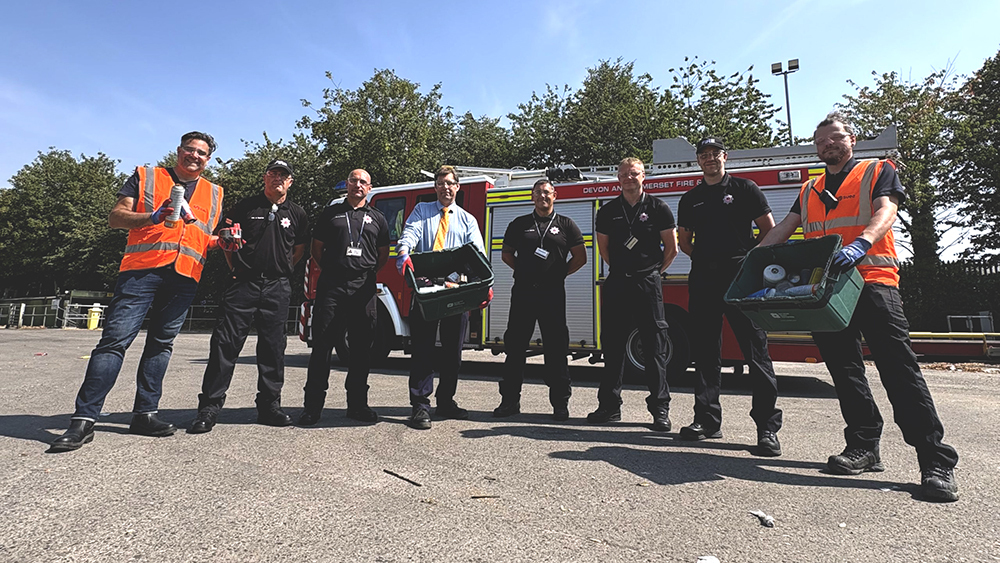 SUEZ recycling staff, fire service personnel and council representatives stand beside a fire engine promoting safe battery disposal.