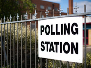 Railings with a sign saying “Polling Station” attached outside a public building.