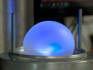 Bioloon prototype, a glowing blue biodegradable membrane balloon, being tested in a laboratory pressure chamber.