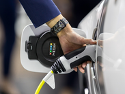 Electric car charging beside a cycle route, illustrating support for lower-emission travel.