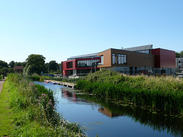 Modern community building beside a canal in Bridgwater South, with waterside greenery reflecting Pride in Place investment.