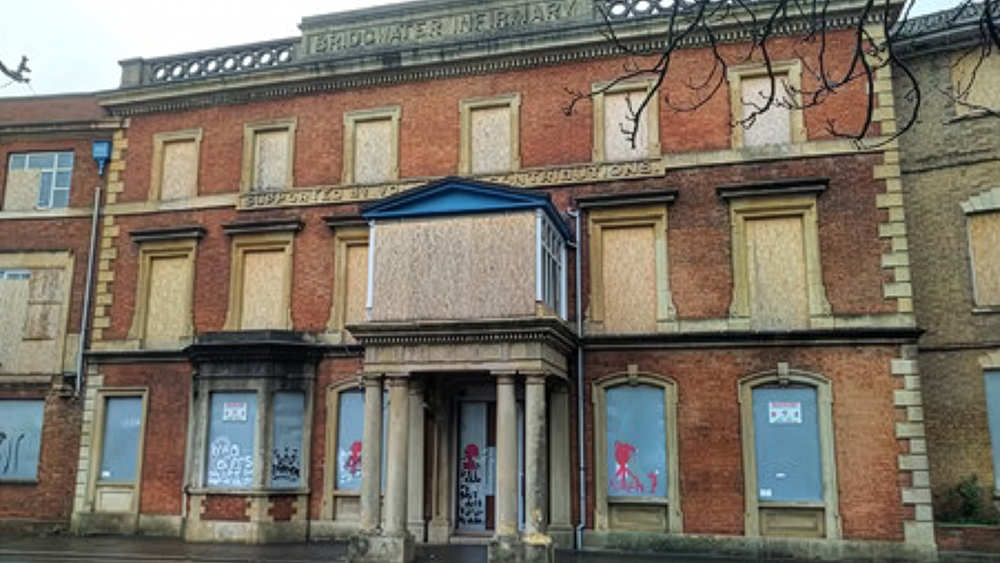 Image of the front of the old Bridgwater Hospital, brick fronted building with boarded up windows