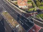 Aerial view of a road junction with segregated cycle lanes, pedestrian routes and nearby homes in Somerset.