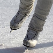 Pair of white ice skating boots on the ice