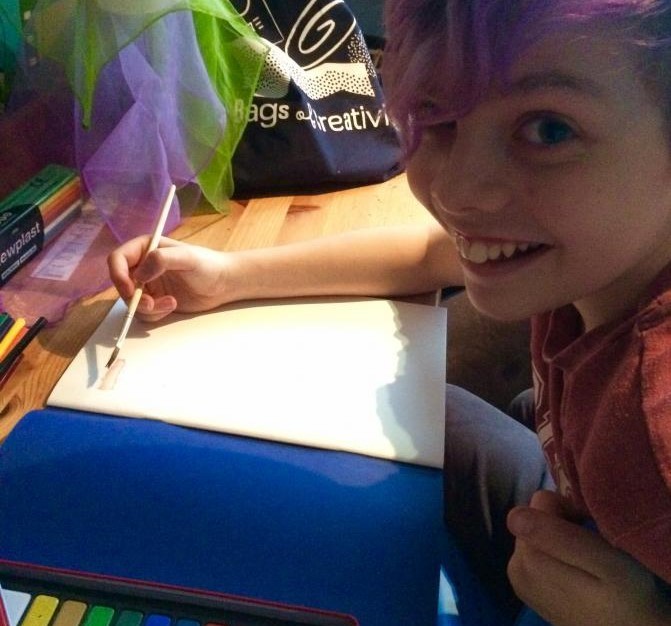 Girl painting with pan paints for bags of creativity