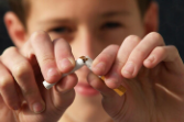 Image of a cigarette being broken in half by a young boy