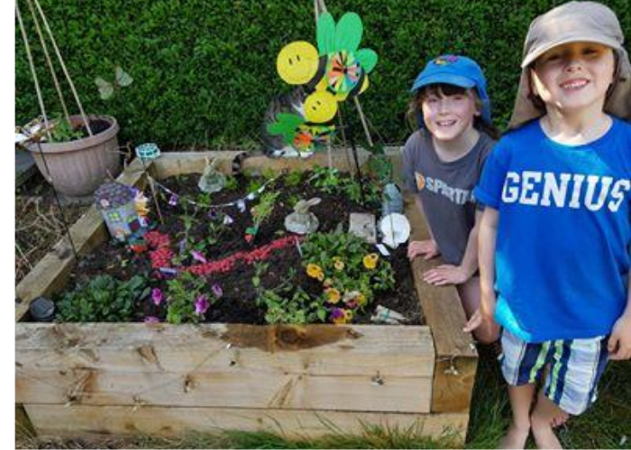 Children standing next to fairy garden project