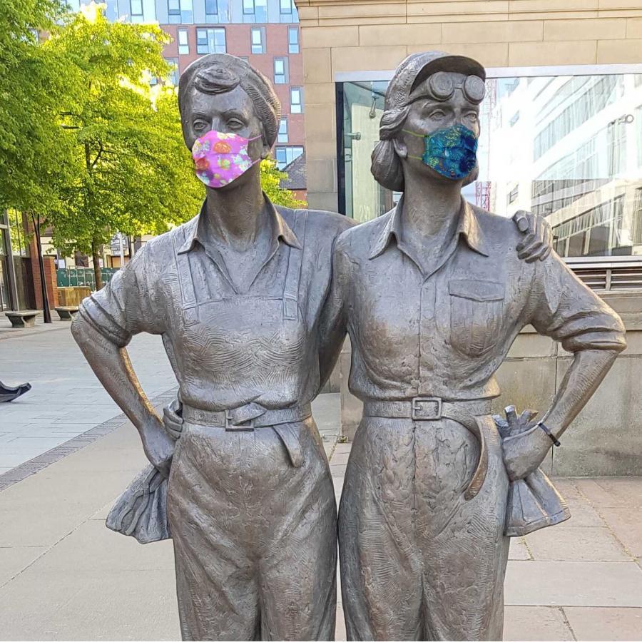 Women of Steel statues wearing face masks