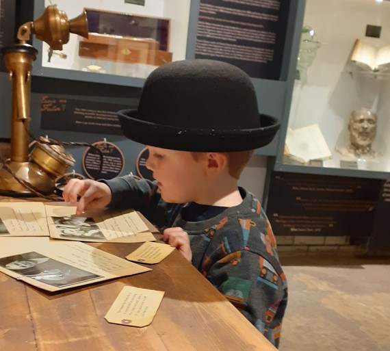 Little boy dressed as a detective looking for clues