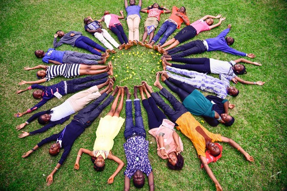 children laid out forming a circle on the grass