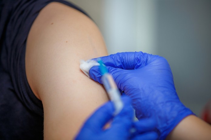 a needle going into an arm for a vaccination