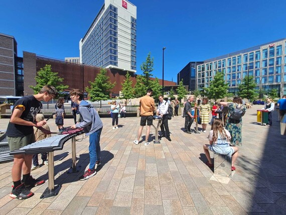 People play on large musical instruments in Sheffield city centre
