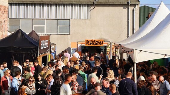 People enjoying sunshine at the previous Peddler Market, with various food stalls around