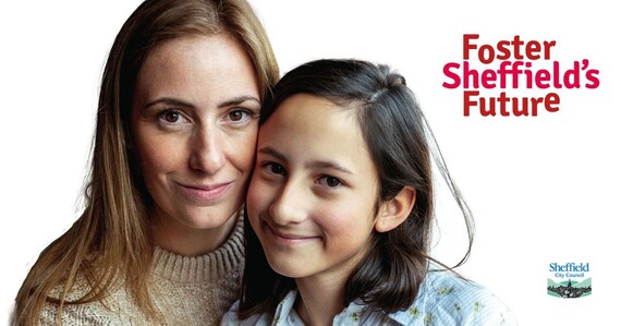 An adult and child hug and smile while standing side by stand. Foster Sheffield's Future