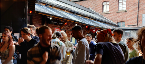 Group of people dancing at the Sidney and Matilda, with a red brick building in the background