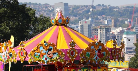 Fairground ride with a yellow and red roof, as Sheffield City Centre can be seen in the distance