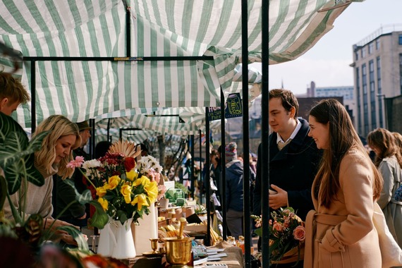 Shoppers at Pollen Market browse flowers, food, and homewares