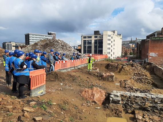 A group in blue hi-vis vests enjoy a tour of the Sheffield castle site by Wessex