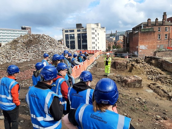 In the midst of the castle site regeneration, a group in blue hi-vis vests take part in a tour