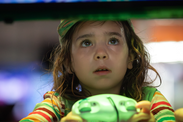 A young child plays a videogame intently