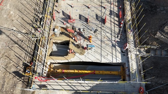 From above, construction site staff wearing orange help with the removal of the River Sheaf culvert