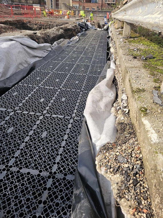 A black drainage cover between the upper and lower parts of the site