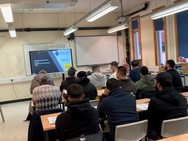 a group of people in a classroom with a trainer