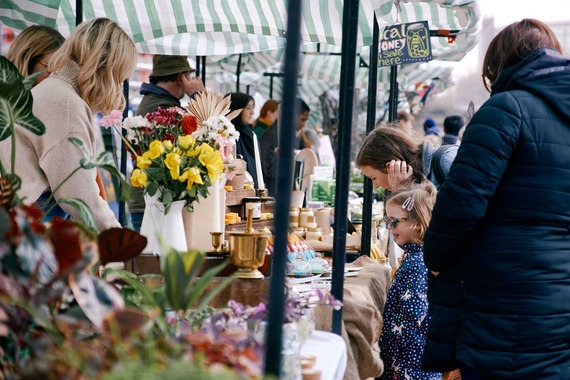 Adults and children browse beautifully colourful stalls packed with plants and produce at Pollen Market.