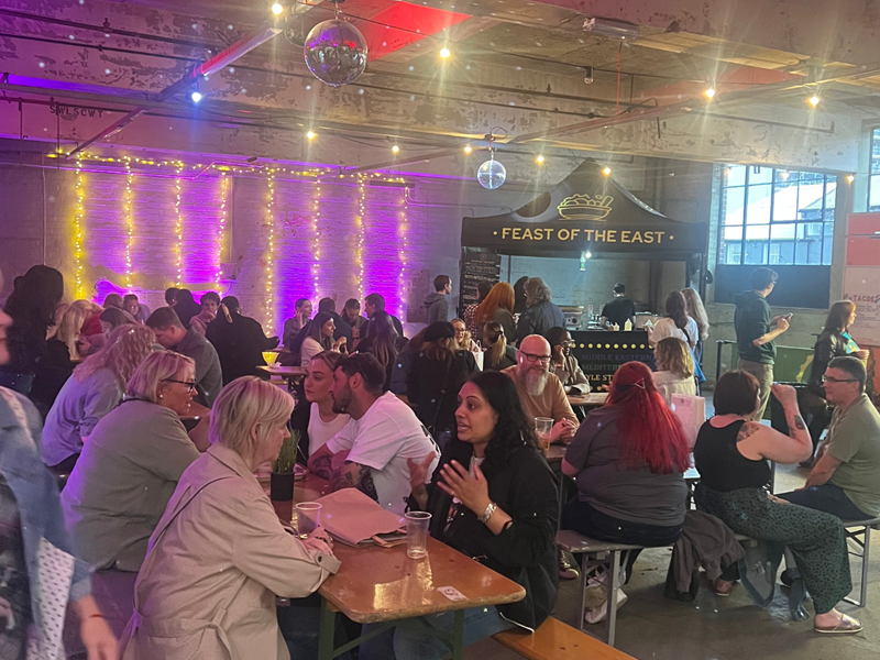 A group of people seated on benches, enjoying food and drink