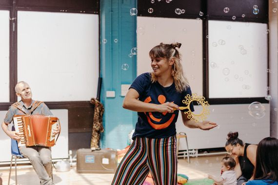 woman blowing bubbles at a concert for babies