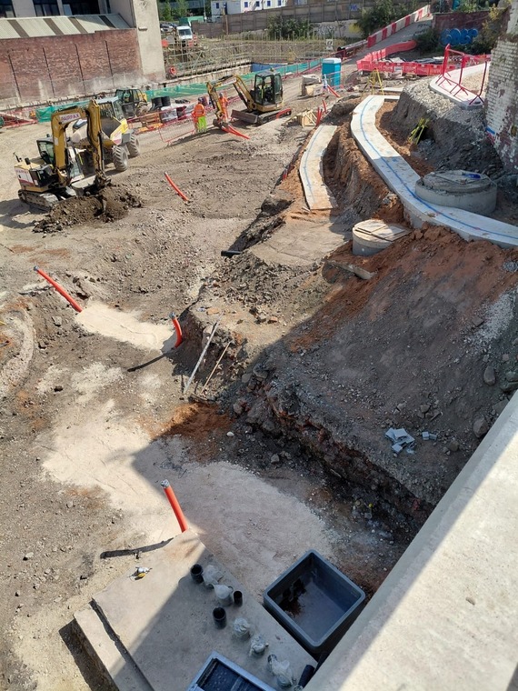Machines and construction workers in hi-vis work next to the new tiered structures on the castle site.