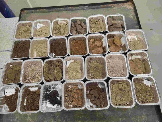 27 takeaway cartons laid out side by side, each filled with a different material