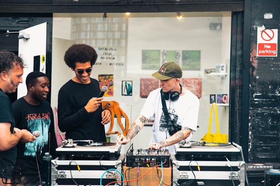 Three people gathered around a DJ at a previous Castlegate Festival.