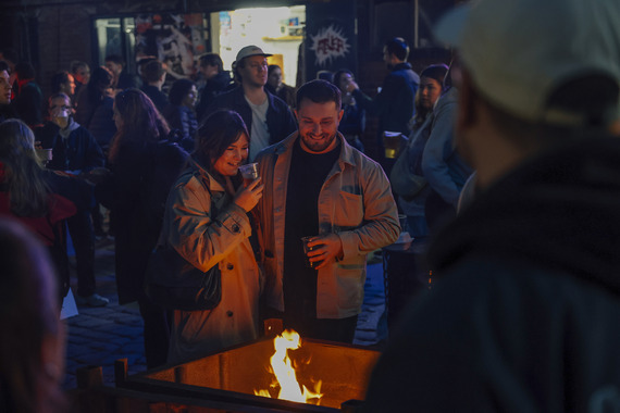 Two people gather around a fire inside Sheffield's Peddler Market