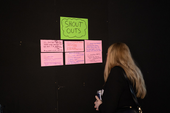 Person looking at colourful call-out cards on black wall.
