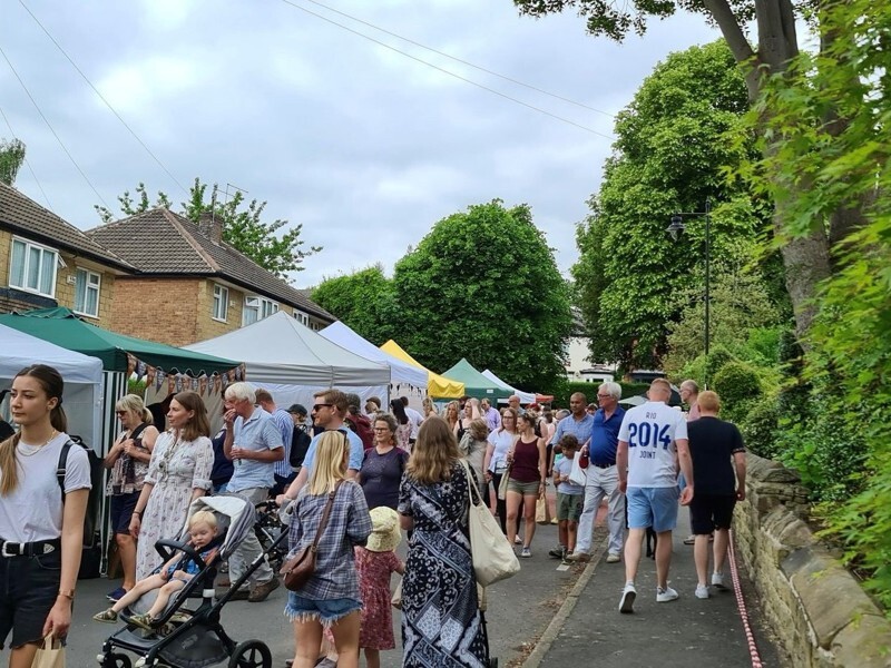 A busy outdoor street market with rows of stalls covered by canopies.