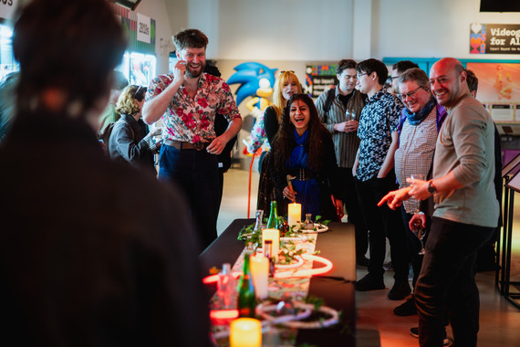 People gathered round a table playing a game and smiling.