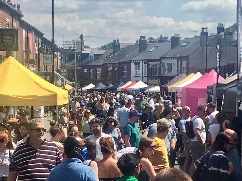 Sharrow Vale Market, with a busy street lined with houses and market stalls.