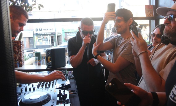 People dancing in front of some dj decks.