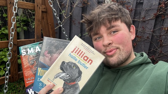 Library assistant Charlie holding three recommended books