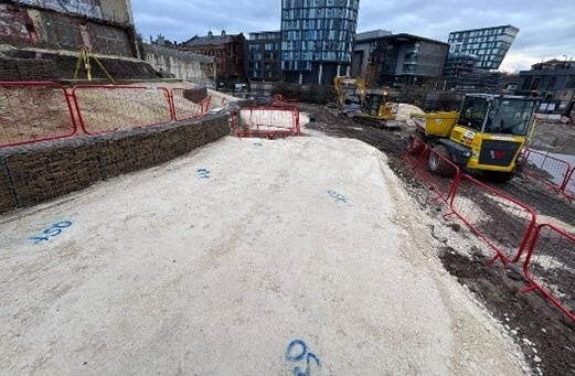 The concrete base on the main route through the park at Castlegate with buildings in the background