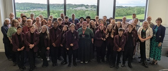A group photo of Newfield Schools students with the Gleadless Valley Regeneration Board in a classroom