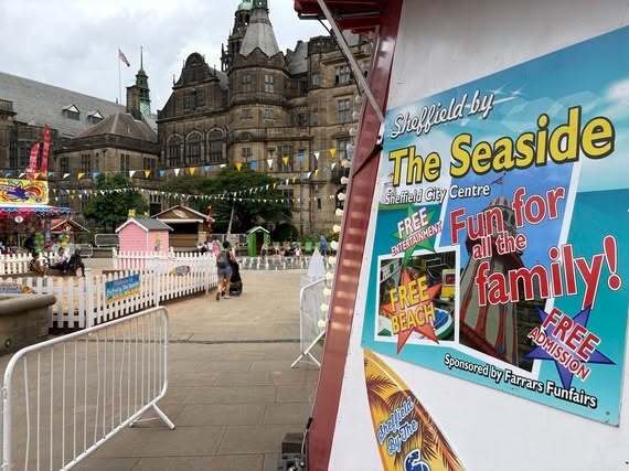 A sign reading 'Sheffield by the Seaside' sits in the Peace Gardens. A sandpit and fountains are visible.