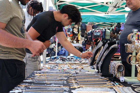 Customers look at gold and silver jewellery on a stall at the Outdoor Market.