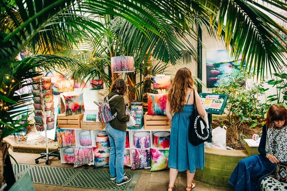 People browse a bright stall in Sheffield Botanical Gardens